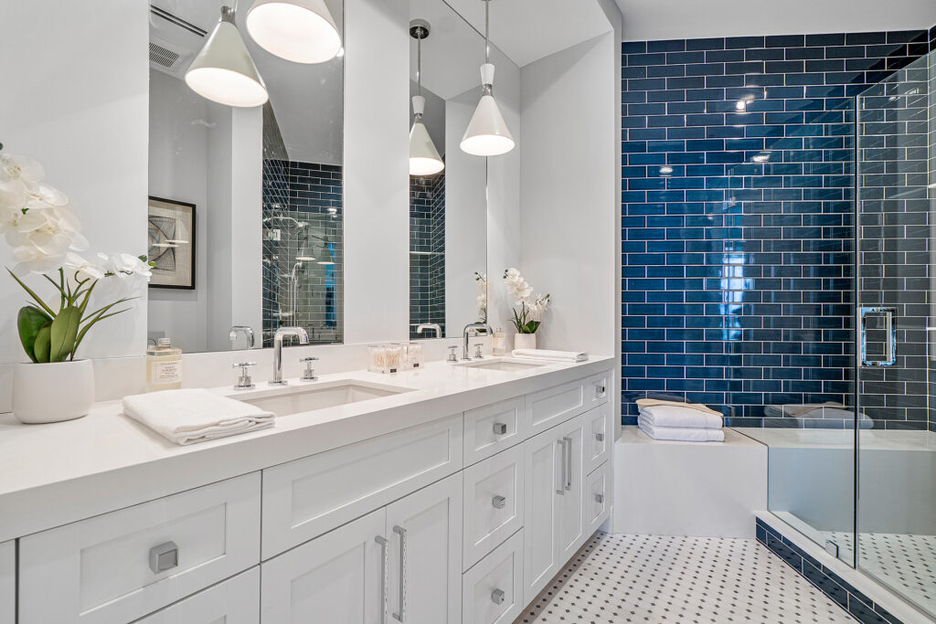 Master bathroom remodel in Algonquin IL with white double vanity, modern lighting, and blue subway tile shower