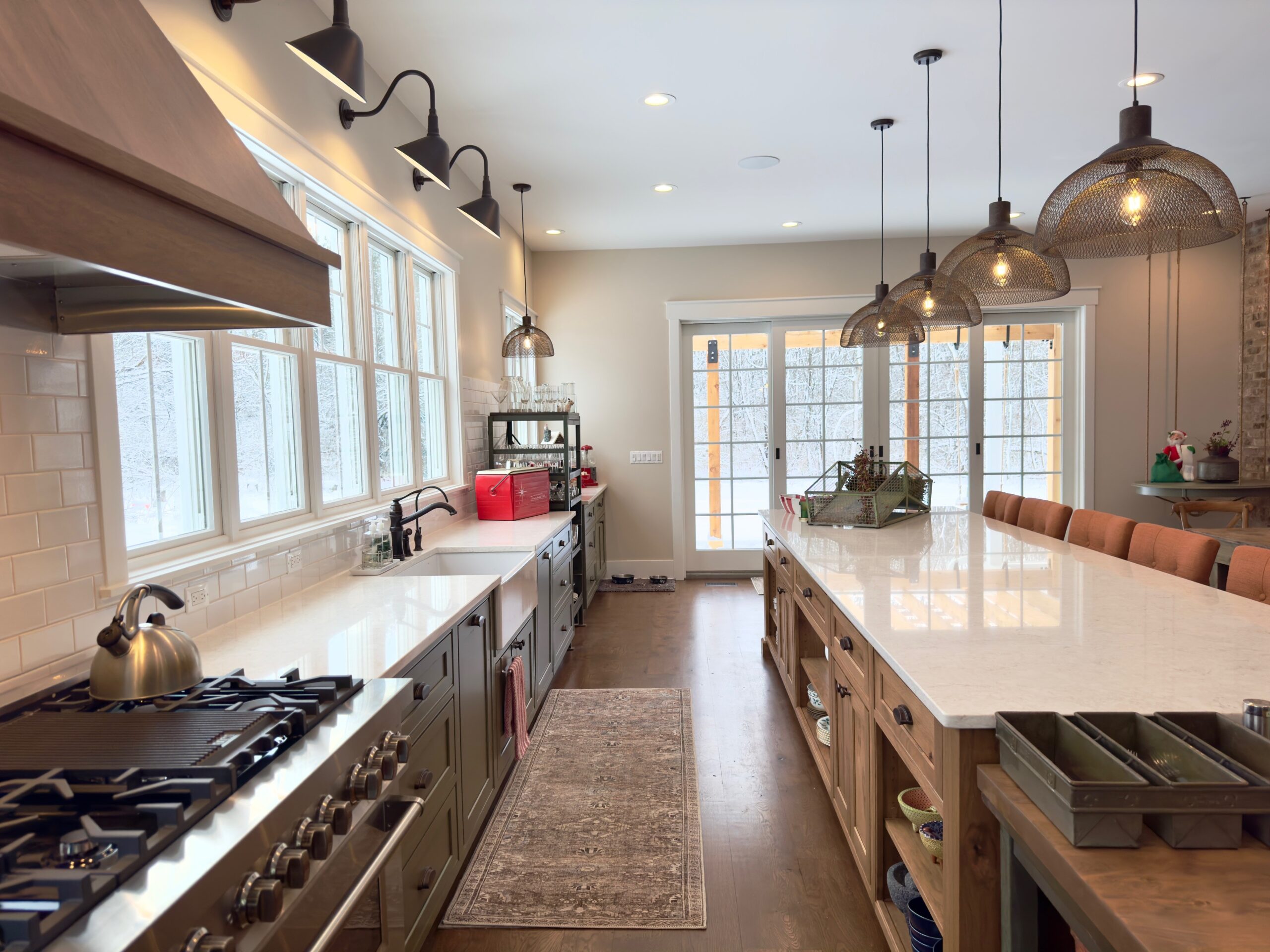 unctional kitchen design featuring a large island, multiple work zones, natural wood cabinetry, and ample countertop space.
