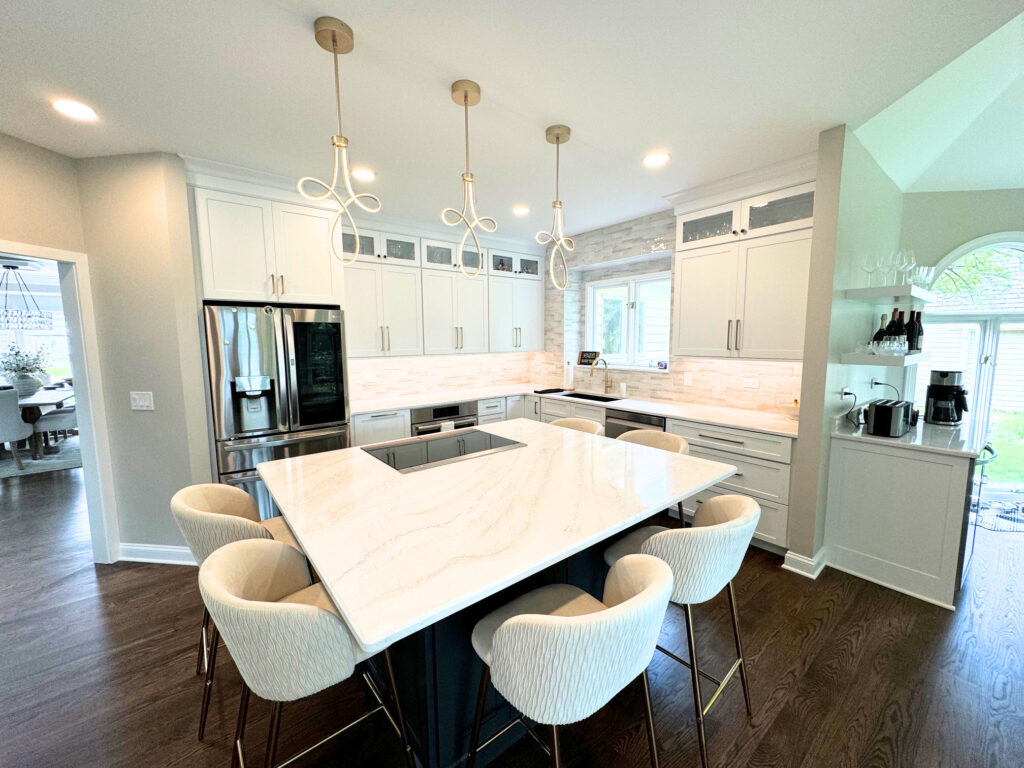 Large quartz island in remodeled Lake in the Hills kitchen with seating and modern lighting