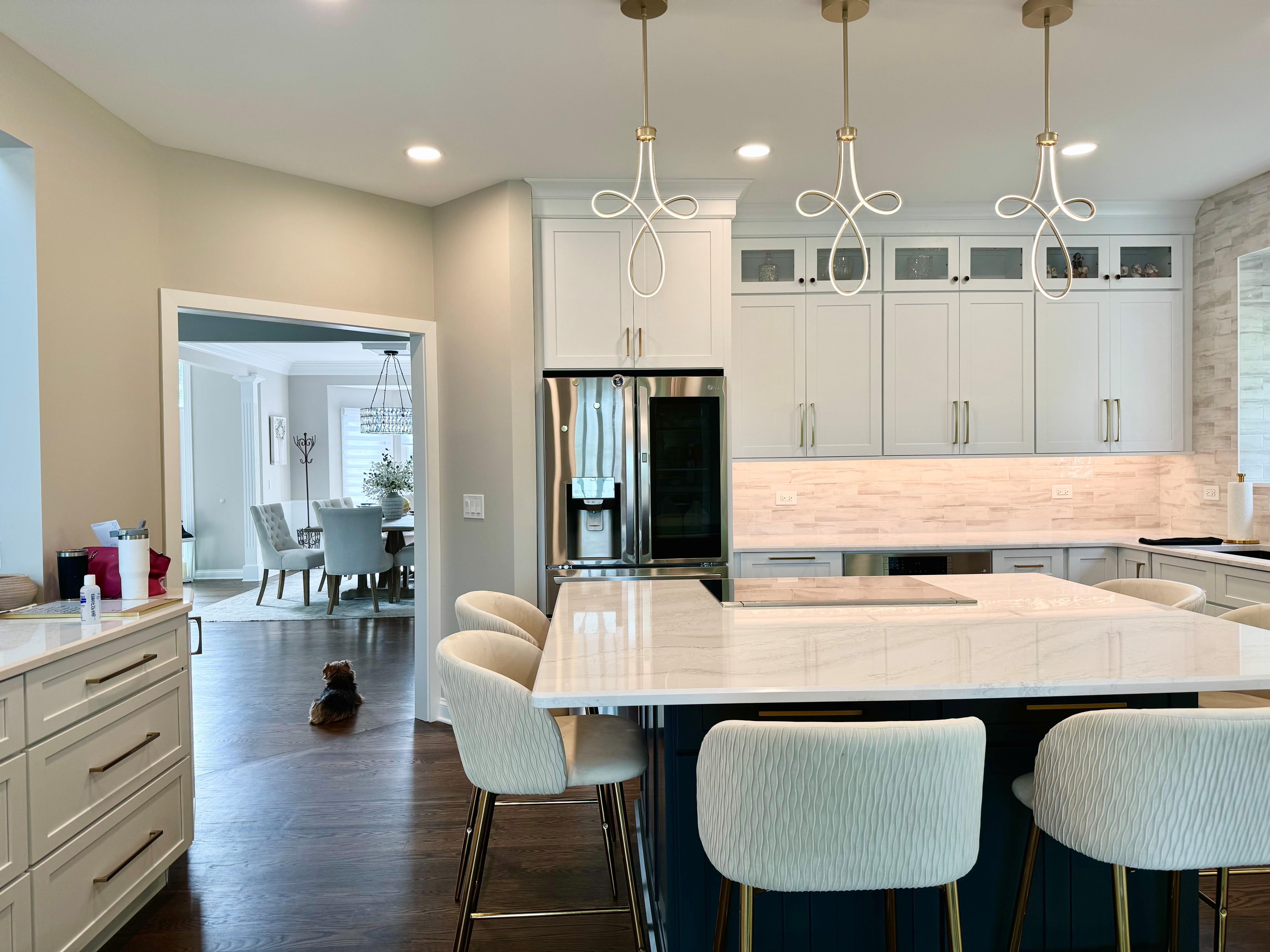 Luxury kitchen remodel in Lake in the Hills IL featuring white cabinetry, quartz countertops, custom island seating, and hardwood flooring
