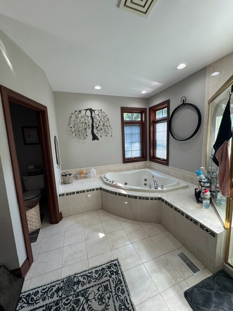 Original oversized corner soaking tub before a luxury bathroom remodel in Woodstock, Illinois by CSL Interior.